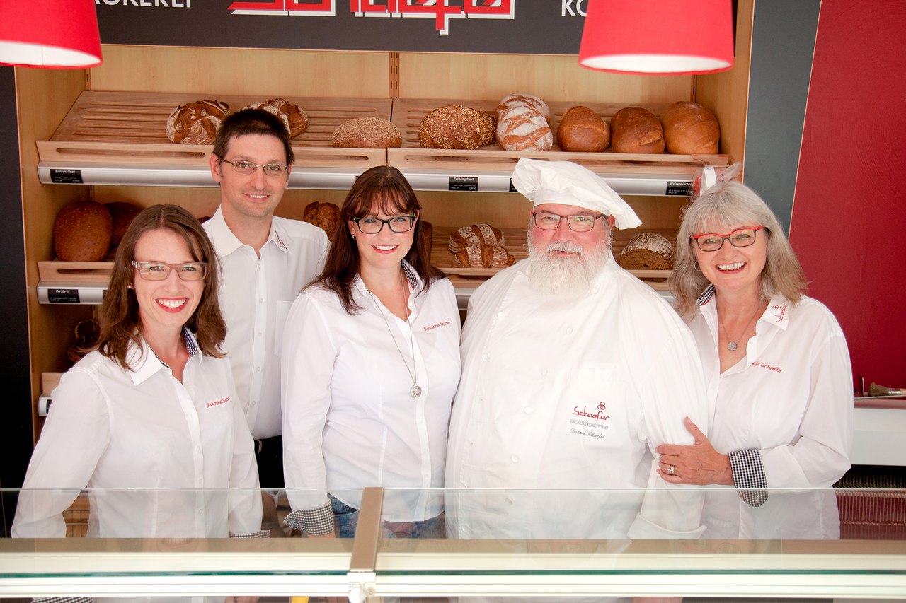 Familie und Team der Bäckerei Schaefer vor den Brotregalen – Originalfoto der Firmenwebsite